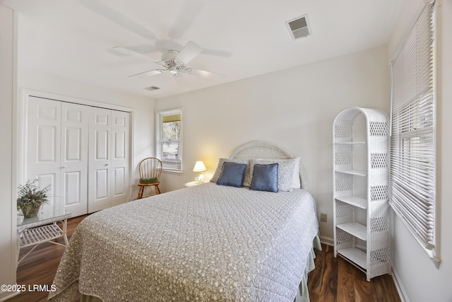 bedroom with dark hardwood / wood-style flooring, ceiling fan, and a closet