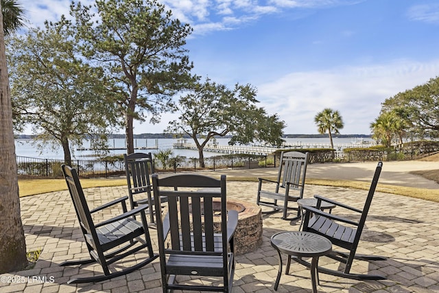 view of patio / terrace with an outdoor fire pit and a water view