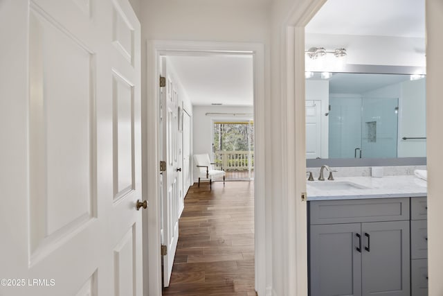 bathroom with vanity, hardwood / wood-style floors, and a shower with shower door