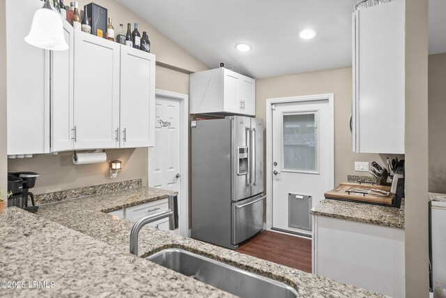 kitchen featuring sink, white cabinetry, light stone counters, dishwasher, and pendant lighting