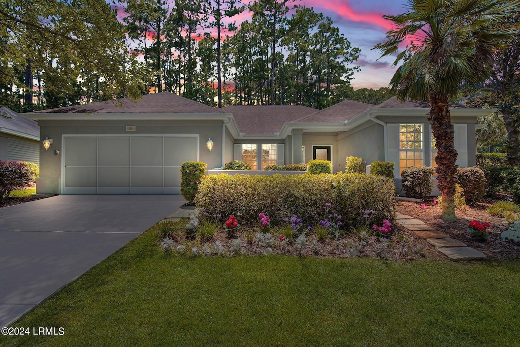 ranch-style house with a yard and a garage