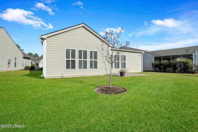 rear view of property featuring a patio and a yard