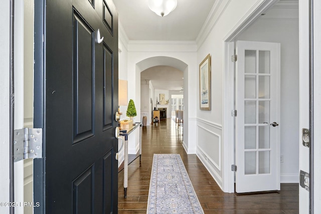 entryway featuring ornamental molding and dark hardwood / wood-style floors