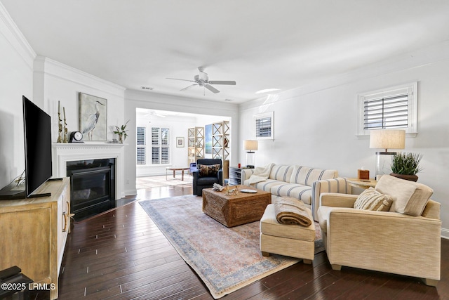 living room with crown molding, ceiling fan, and dark hardwood / wood-style floors