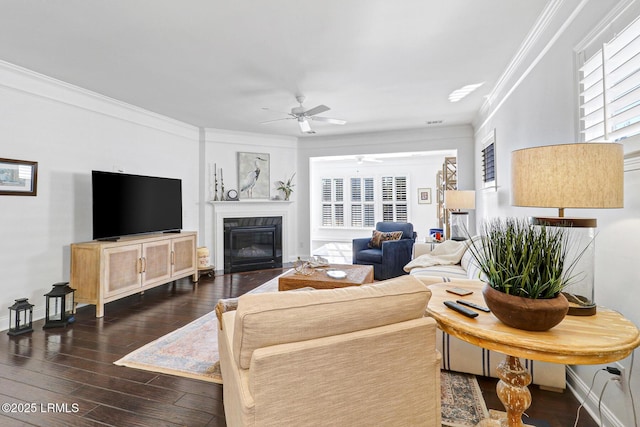 living room featuring crown molding, ceiling fan, a high end fireplace, and dark hardwood / wood-style floors