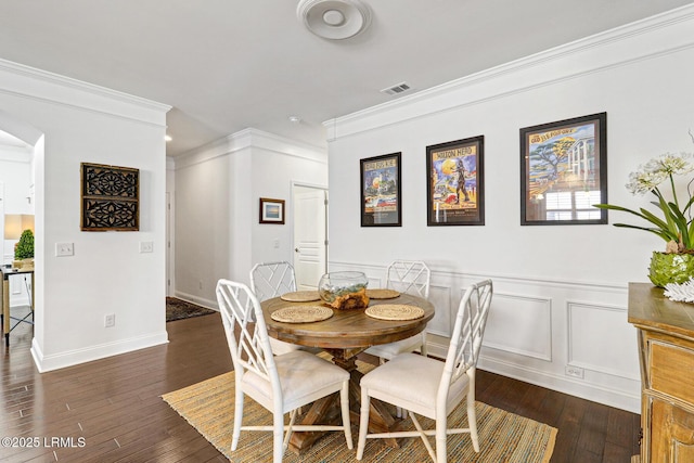 dining room with ornamental molding and dark hardwood / wood-style flooring