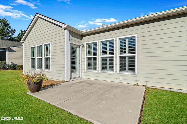 back of property featuring a lawn and a patio