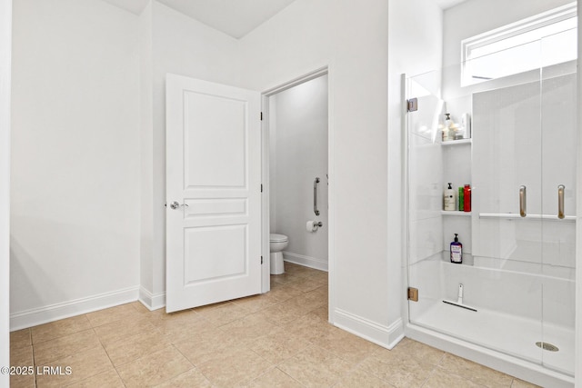 bathroom with tile patterned flooring, a shower with shower door, and toilet