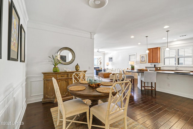 dining area with ornamental molding, a healthy amount of sunlight, and dark hardwood / wood-style floors