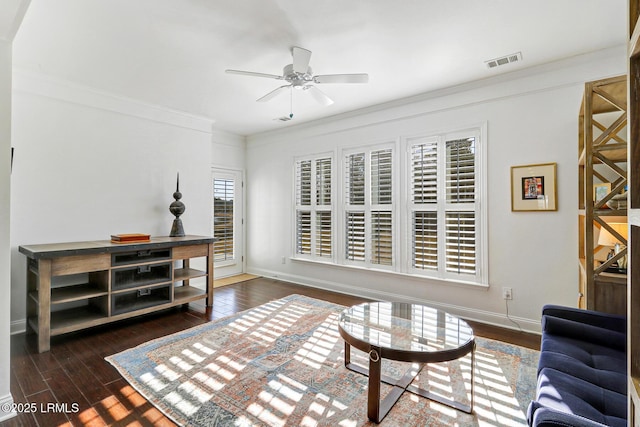 living room with crown molding, dark wood-type flooring, and ceiling fan