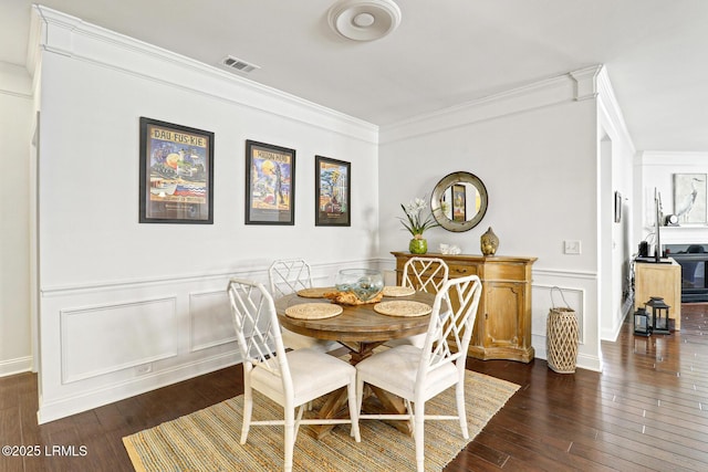 dining area featuring dark hardwood / wood-style flooring and ornamental molding