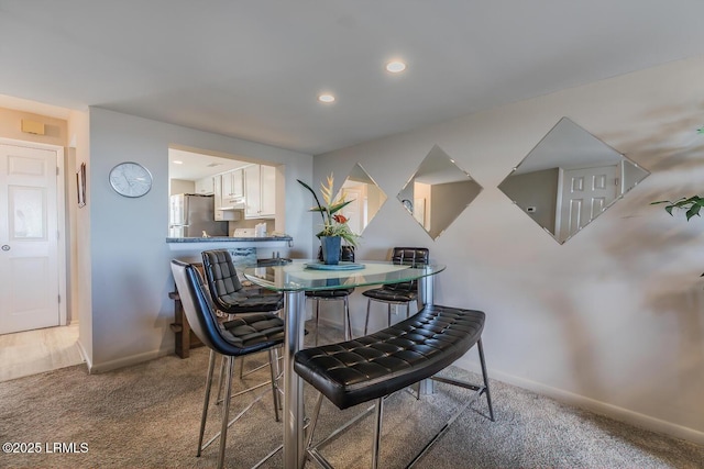 carpeted dining area with baseboards and recessed lighting