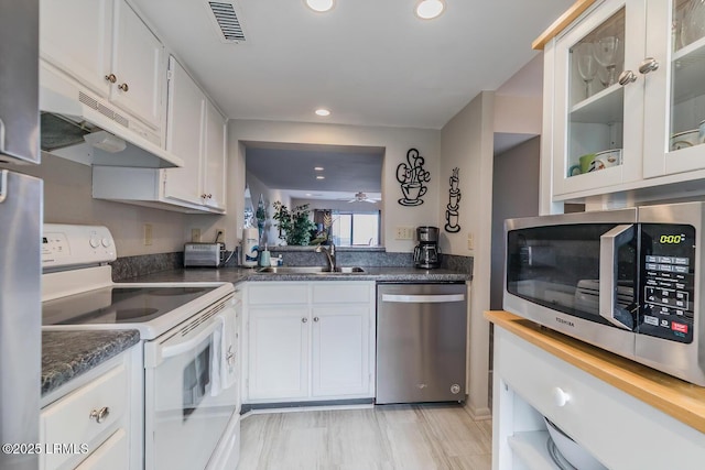 kitchen with appliances with stainless steel finishes, a sink, recessed lighting, under cabinet range hood, and white cabinetry
