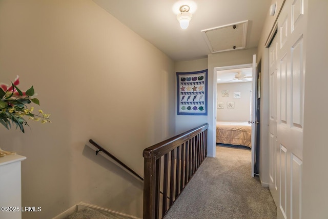 hall featuring an upstairs landing and carpet flooring