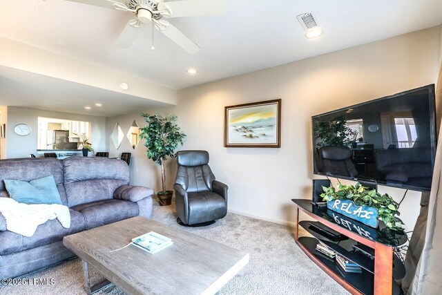 carpeted living area with a ceiling fan, baseboards, and recessed lighting