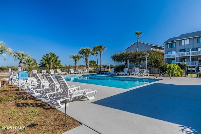 community pool featuring fence and a patio area