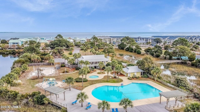 community pool with a hot tub and a deck with water view
