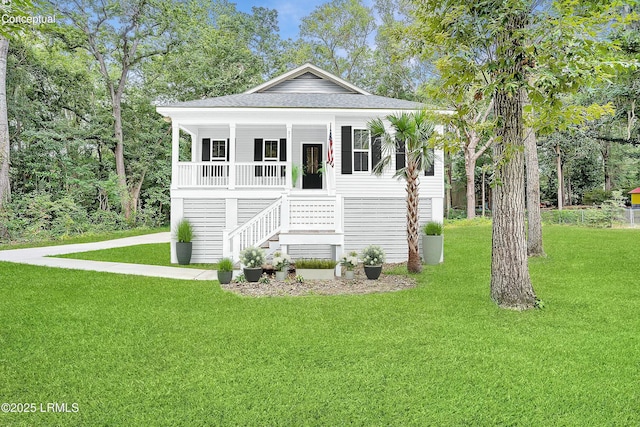 view of front of home featuring a shingled roof, stairs, a porch, and a front yard