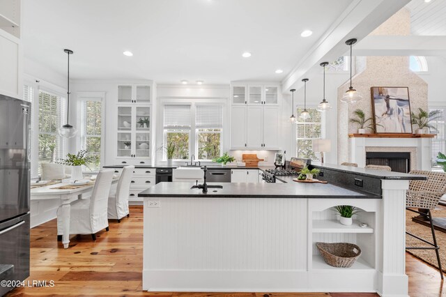 kitchen with hanging light fixtures, light hardwood / wood-style floors, and white cabinets