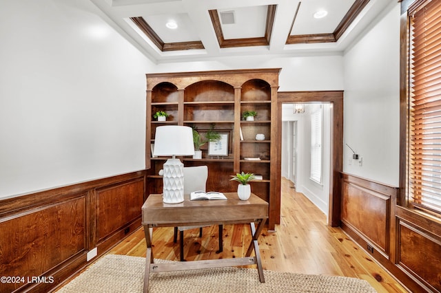 office space with coffered ceiling, ornamental molding, a wealth of natural light, beamed ceiling, and light hardwood / wood-style floors