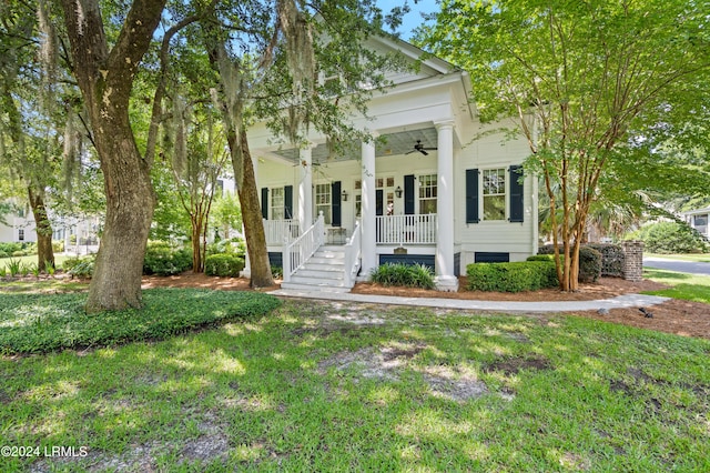 neoclassical / greek revival house with ceiling fan, a porch, and a front yard