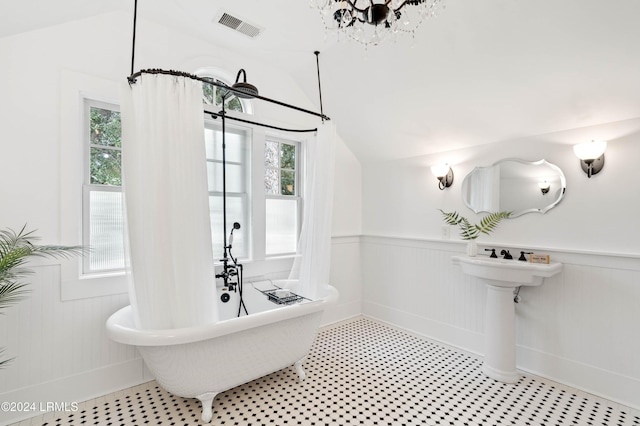 bathroom with lofted ceiling and a tub