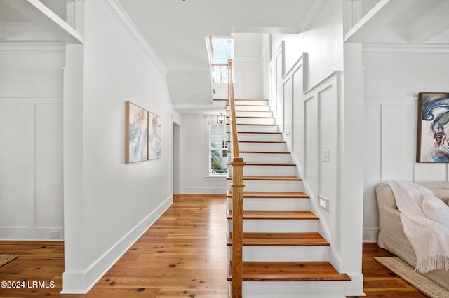 stairs featuring hardwood / wood-style flooring and crown molding