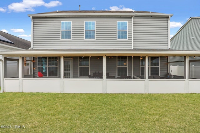 back of house with a sunroom and a yard