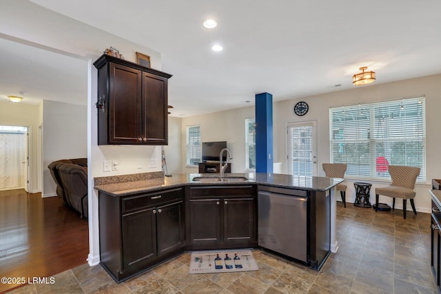 kitchen with recessed lighting, stainless steel dishwasher, a sink, dark brown cabinets, and a peninsula