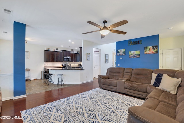 living area featuring baseboards, visible vents, ceiling fan, dark wood-type flooring, and recessed lighting