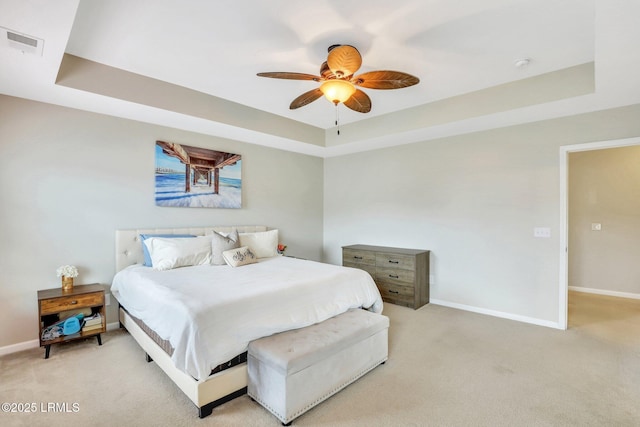 bedroom with baseboards, visible vents, a raised ceiling, a ceiling fan, and light colored carpet