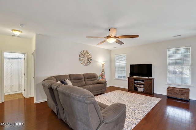 living area featuring dark wood-style floors, a healthy amount of sunlight, visible vents, and ceiling fan