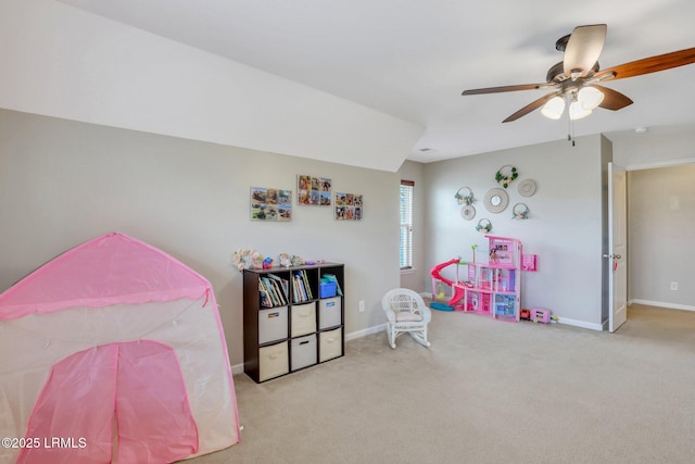 recreation room featuring light colored carpet, ceiling fan, and baseboards