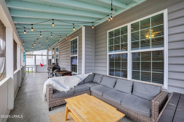 sunroom / solarium featuring track lighting and beamed ceiling