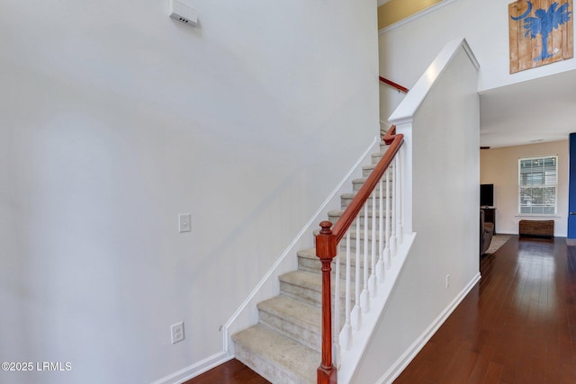 staircase featuring baseboards and wood finished floors