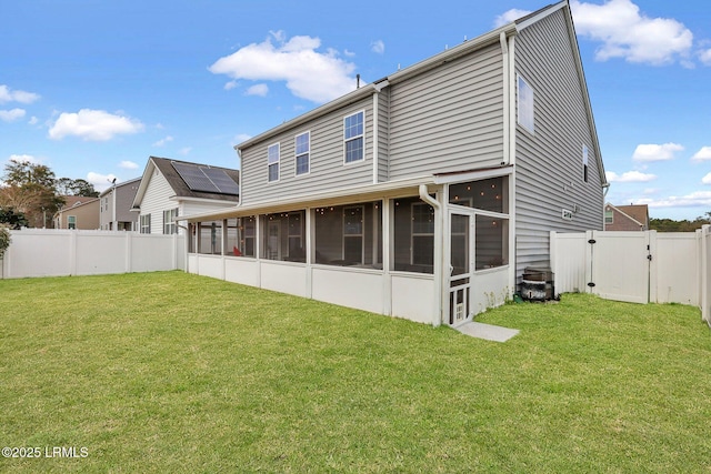 rear view of house featuring a sunroom, a fenced backyard, a lawn, and a gate