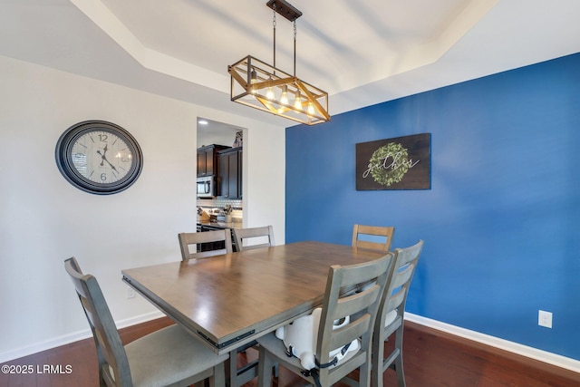 dining area featuring dark wood-type flooring and baseboards