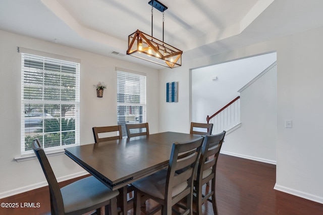 dining area featuring a healthy amount of sunlight, dark wood-style floors, baseboards, and visible vents