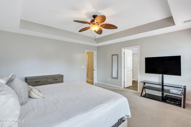 bedroom with light carpet, visible vents, and a raised ceiling