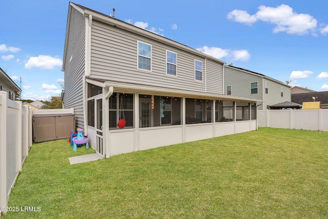 rear view of house featuring a sunroom, a fenced backyard, and a yard