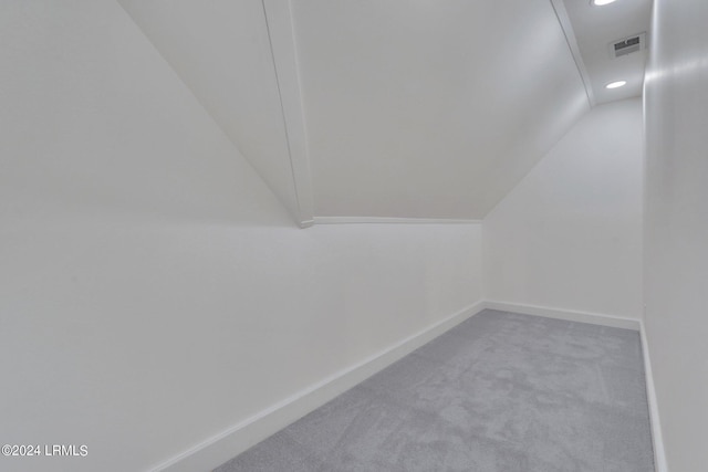 interior space featuring vaulted ceiling and carpet