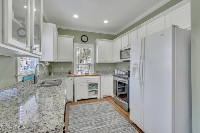 kitchen with white cabinetry, ornamental molding, appliances with stainless steel finishes, and sink