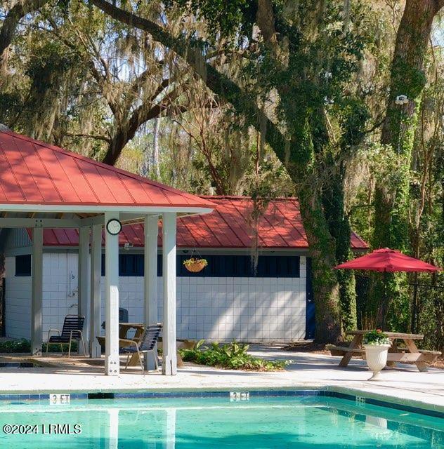 view of pool with an outbuilding and a patio