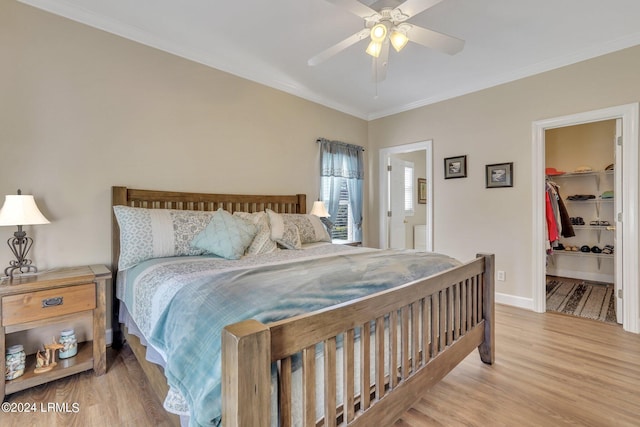 bedroom featuring ensuite bath, ceiling fan, wood-type flooring, a walk in closet, and a closet