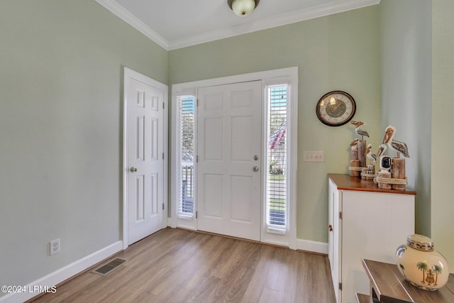 foyer with ornamental molding and light wood-type flooring