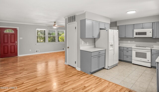 kitchen featuring gray cabinets, white appliances, and light hardwood / wood-style flooring