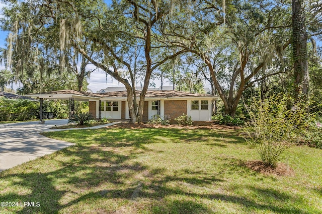 ranch-style house featuring a carport and a front lawn