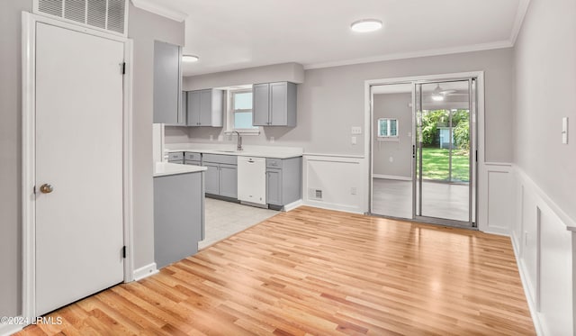 kitchen featuring gray cabinets, a wealth of natural light, white dishwasher, and light hardwood / wood-style floors