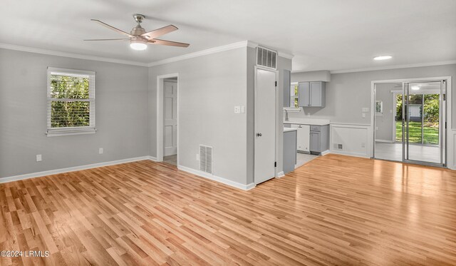 unfurnished living room with ornamental molding, a wealth of natural light, ceiling fan, and light wood-type flooring