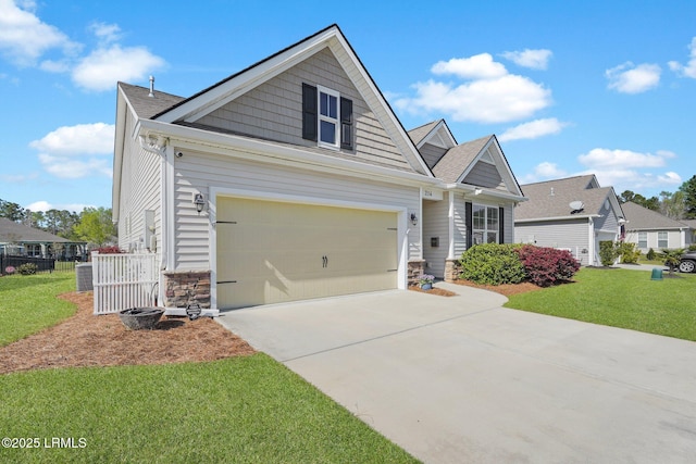 214 Lombards Mill Ln, Okatie, SC 29909 - view of front of home with stone siding, concrete driveway, fence, a front lawn, and a shingled roof